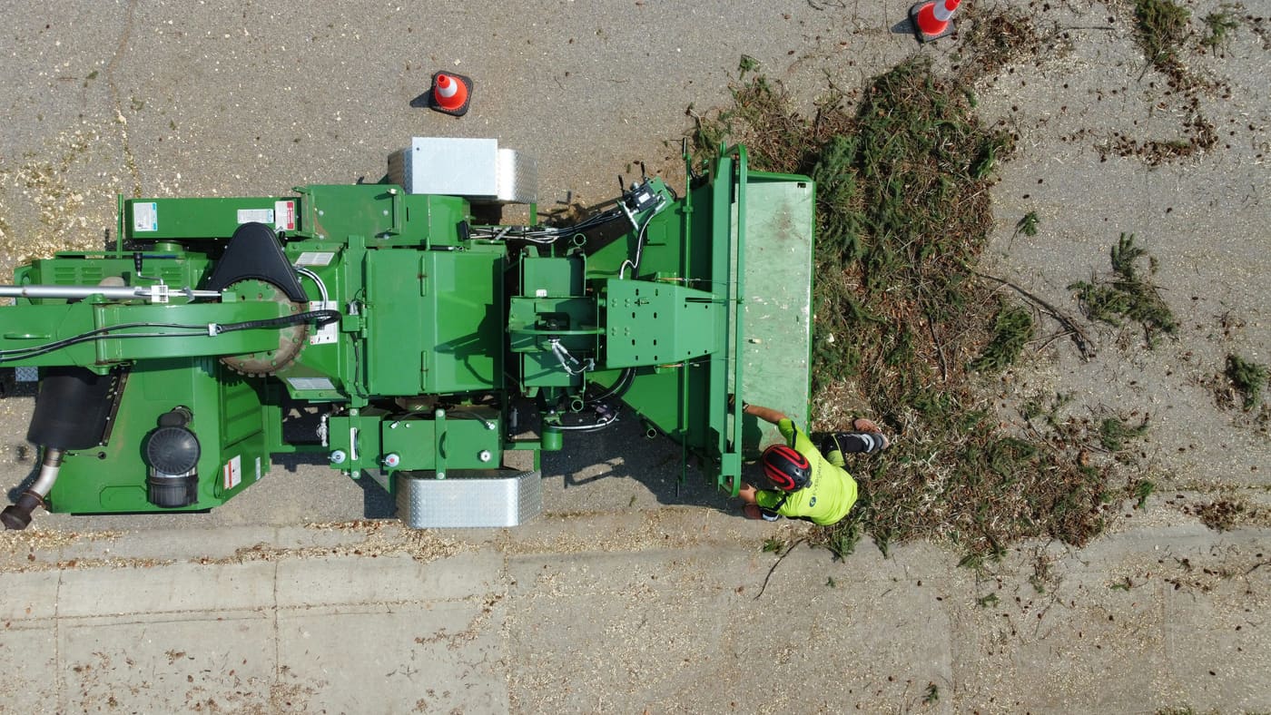 Drum chipper processing brush during a tree removal cleanup